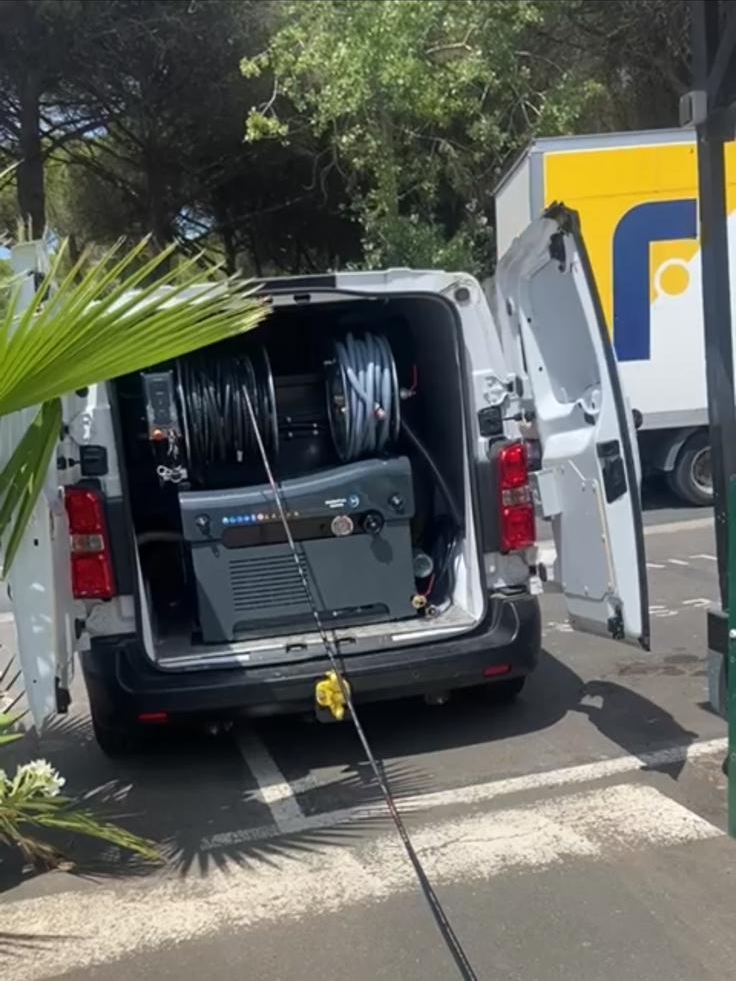 Camion HYDREX ouvert sur une intervention, enrouleur haute pression et flexible déroulé jusqu’au regard