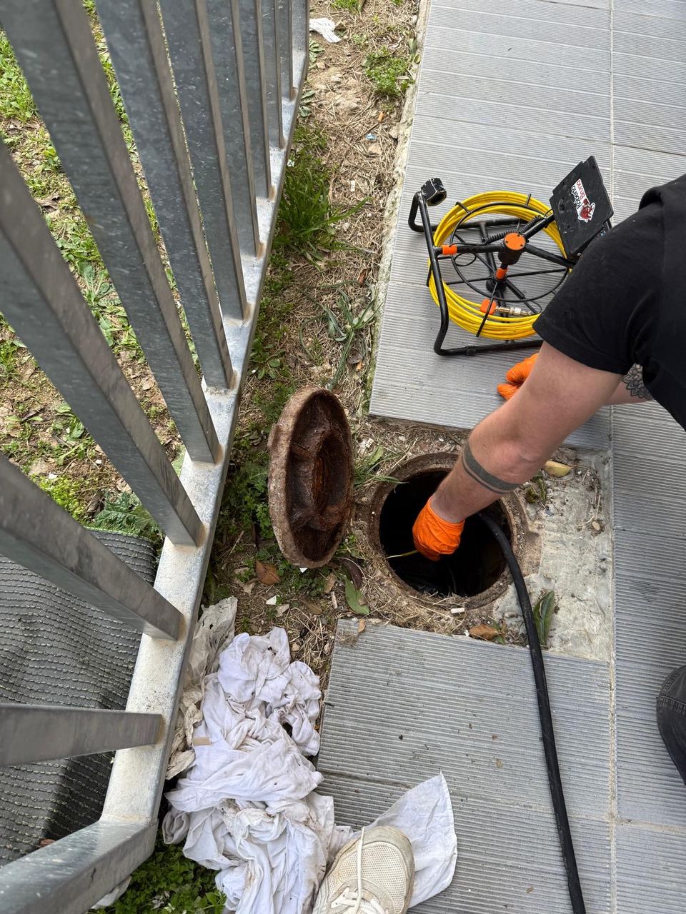 Technicien HYDREX descendant la caméra d’inspection dans un regard de visite ouvert