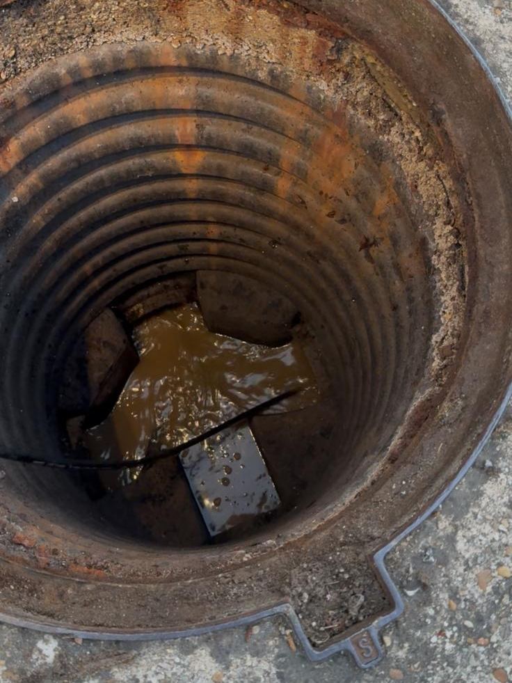 Regard d’assainissement engorgé, eau stagnante et dépôts avant intervention